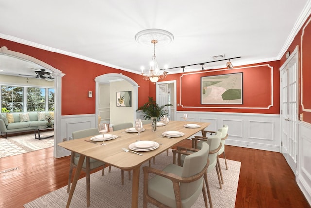 2 Ann Pl, Valhalla, NY 10595 - dining room featuring arched walkways, a chandelier, rail lighting, a decorative wall, and wainscoting