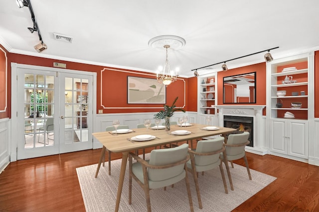 2 Ann Pl, Valhalla, NY 10595 - dining area with rail lighting, a lit fireplace, wood finished floors, french doors, and a chandelier