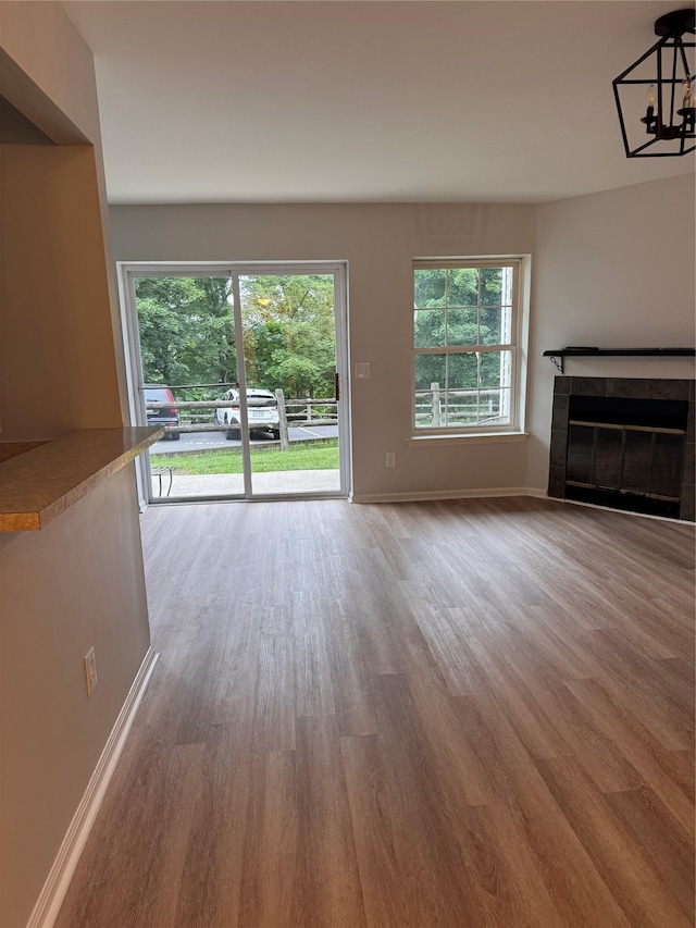 21 Lexington Hl Unit 8, Harriman, NY 10926 - unfurnished living room with wood finished floors, a fireplace, and a chandelier