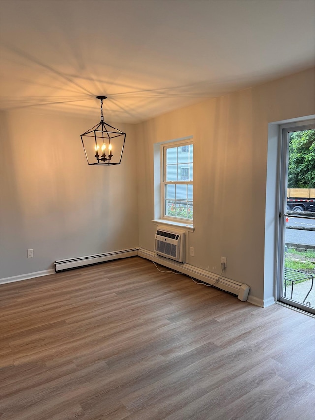 21 Lexington Hl Unit 8, Harriman, NY 10926 - spare room featuring a baseboard heating unit, a chandelier, wood finished floors, baseboard heating, and a wall unit AC