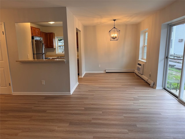 21 Lexington Hl Unit 8, Harriman, NY 10926 - unfurnished dining area featuring a chandelier, light wood-style floors, and a baseboard heating unit