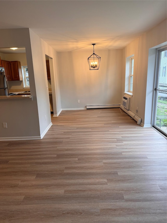 21 Lexington Hl Unit 8, Harriman, NY 10926 - unfurnished dining area with a chandelier, wood finished floors, a wall mounted AC, and a baseboard radiator