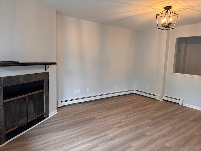 21 Lexington Hl Unit 8, Harriman, NY 10926 - unfurnished living room featuring wood finished floors, a baseboard radiator, a chandelier, and a tiled fireplace