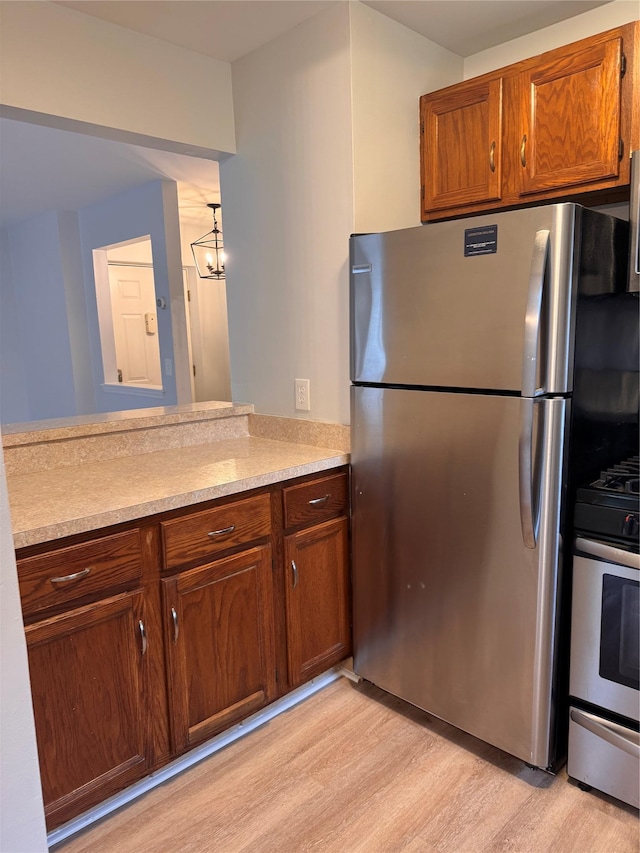 21 Lexington Hl Unit 8, Harriman, NY 10926 - kitchen featuring appliances with stainless steel finishes, light wood-style flooring, light countertops, a peninsula, and a chandelier