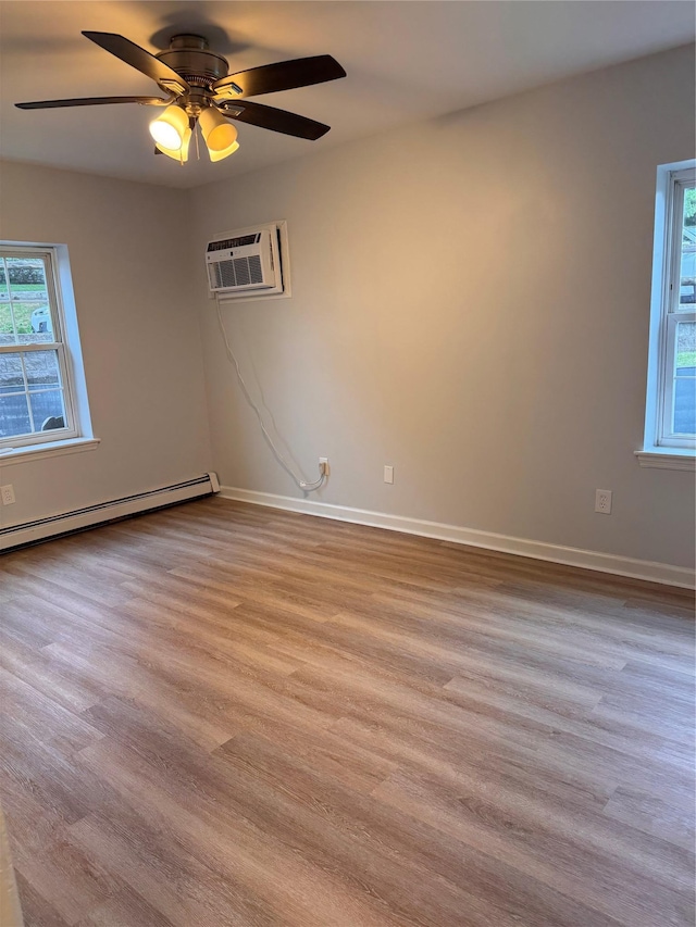 21 Lexington Hl Unit 8, Harriman, NY 10926 - empty room with a wall unit AC, light wood-style floors, a baseboard heating unit, and a ceiling fan