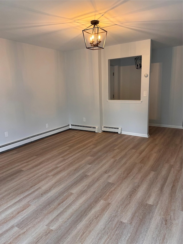 21 Lexington Hl Unit 8, Harriman, NY 10926 - spare room featuring a baseboard radiator, wood finished floors, and a chandelier