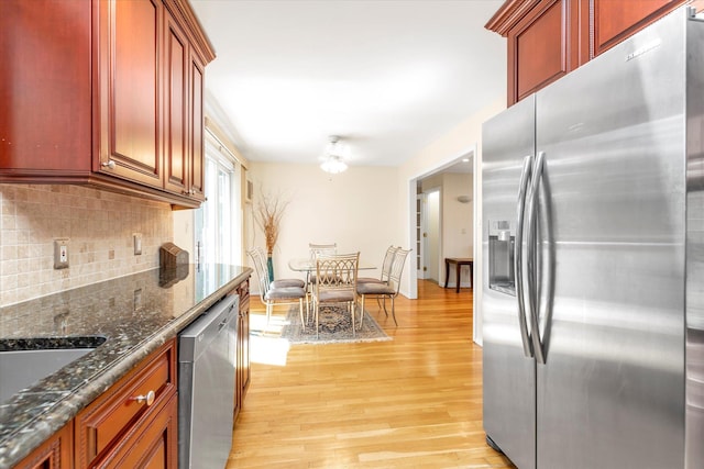 18 Gainsboro Ln, Syosset, NY 11791 - kitchen with appliances with stainless steel finishes, light wood-style flooring, decorative backsplash, dark brown cabinets, and dark stone counters