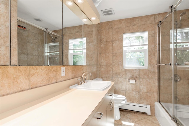 18 Gainsboro Ln, Syosset, NY 11791 - bathroom with baseboard heating, tile walls, tile patterned floors, vanity, and bath / shower combo with glass door