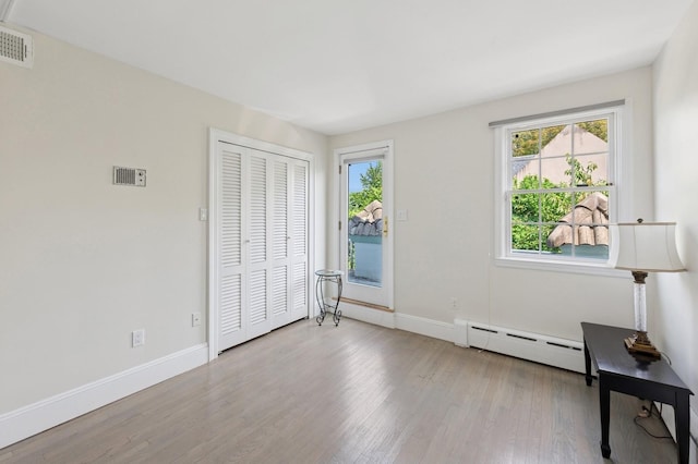 24-56 Little Neck Blvd, Bayside, NY 11360 - unfurnished bedroom featuring a baseboard heating unit, wood finished floors, access to exterior, and a closet