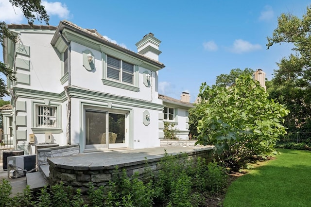 24-56 Little Neck Blvd, Bayside, NY 11360 - rear view of property with a chimney, stucco siding, a yard, and a patio area