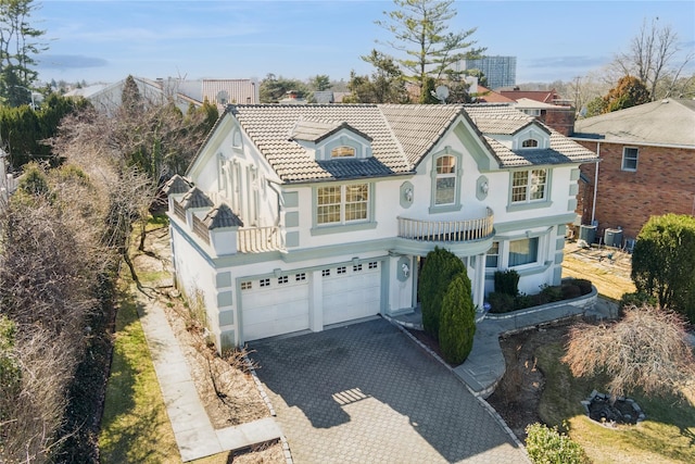 24-56 Little Neck Blvd, Bayside, NY 11360 - view of front of house with stucco siding, asphalt driveway, a balcony, an attached garage, and a tile roof