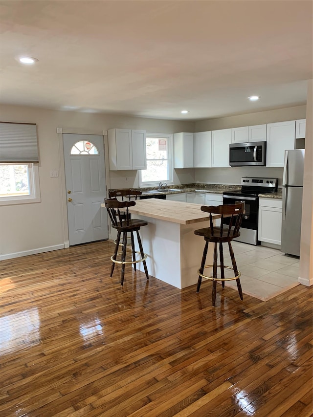 604 Basket Rd, Long Eddy, NY 12760 - kitchen featuring appliances with stainless steel finishes, light wood finished floors, a breakfast bar, recessed lighting, and white cabinets
