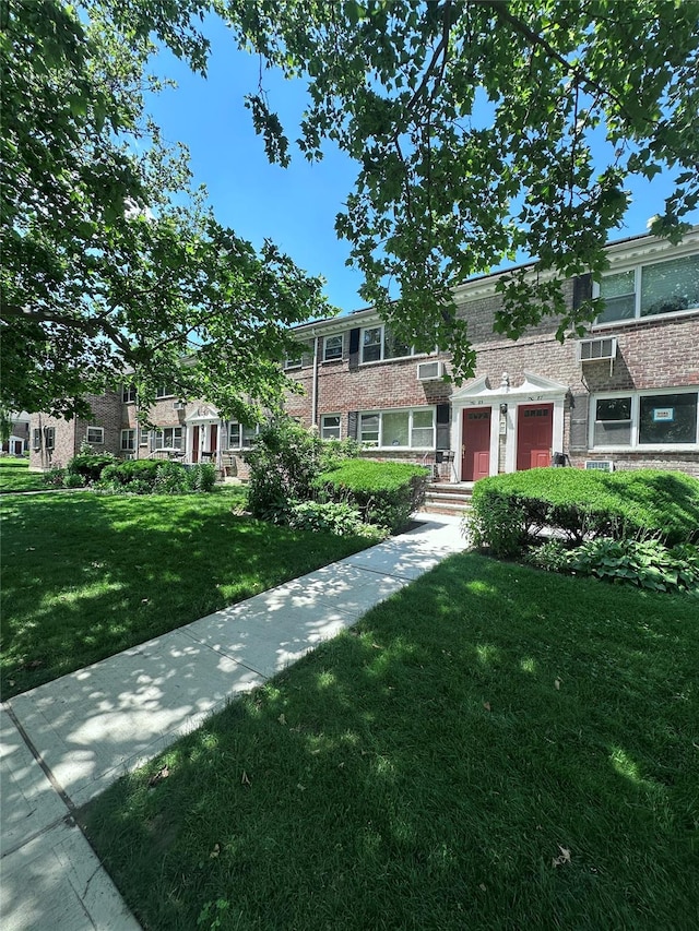 150-85 70th Rd Unit 2B, Flushing, NY 11367 - townhome / multi-family property with a garage, a front lawn, and brick siding