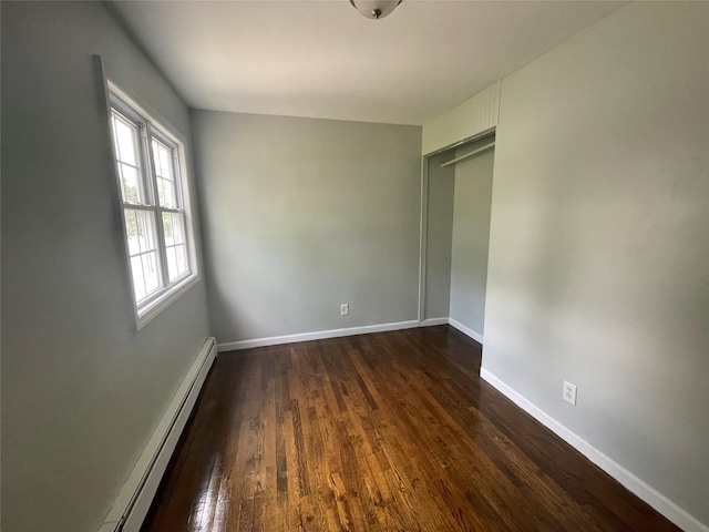 10 Kirby Ln, Central Islip, NY 11722 - unfurnished bedroom featuring a baseboard radiator and dark wood-style floors