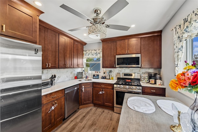 89 3rd Ave, Massapequa Park, NY 11762 - kitchen featuring stainless steel appliances, light countertops, light wood-style floors, tasteful backsplash, and recessed lighting