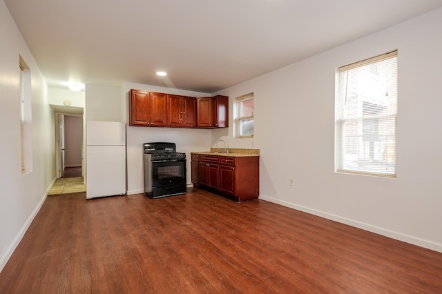 989 Sacket Ave, Bronx, NY 10462 - kitchen with freestanding refrigerator, black range with gas cooktop, dark wood-style flooring, and recessed lighting