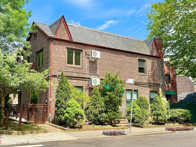 7267 Yellowstone Blvd, Forest Hills, NY 11375 - view of front of home featuring a high end roof, a chimney, and brick siding