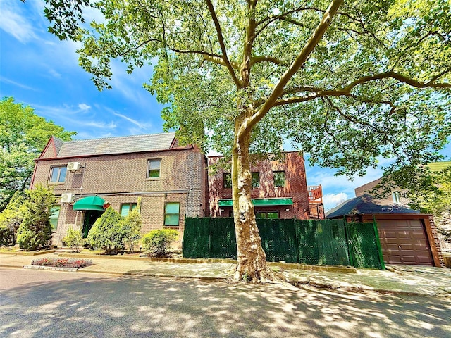 7267 Yellowstone Blvd, Forest Hills, NY 11375 - view of front facade featuring a garage, brick siding, and driveway
