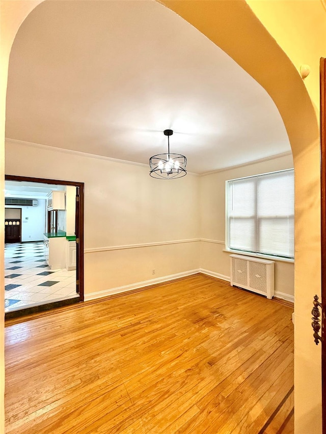 7267 Yellowstone Blvd, Forest Hills, NY 11375 - spare room featuring radiator heating unit, hardwood / wood-style floors, and arched walkways