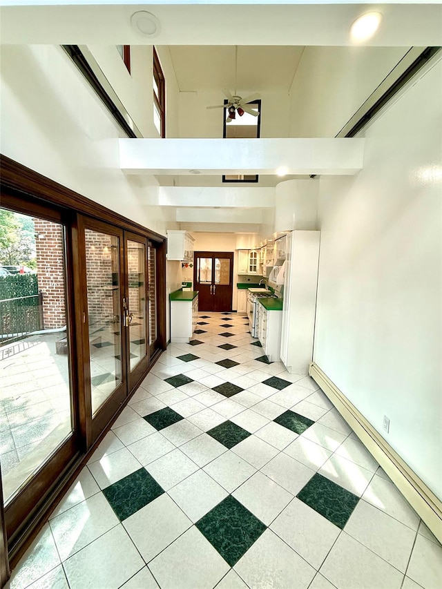 7267 Yellowstone Blvd, Forest Hills, NY 11375 - corridor with baseboard heating, a towering ceiling, french doors, and light tile patterned floors