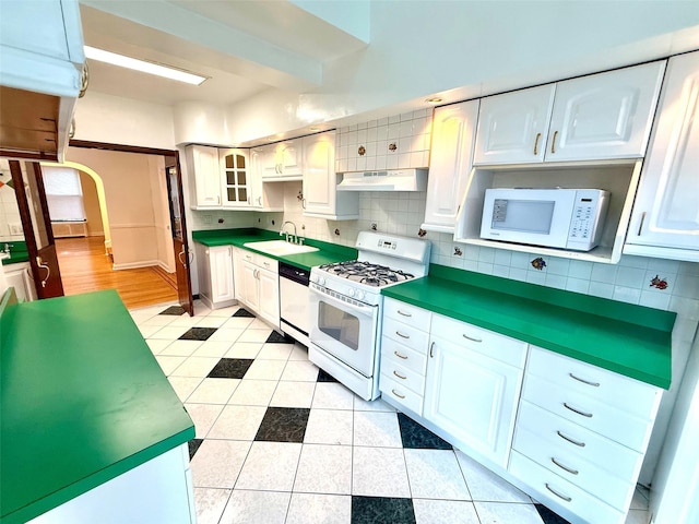 7267 Yellowstone Blvd, Forest Hills, NY 11375 - kitchen featuring white appliances, under cabinet range hood, light tile patterned flooring, backsplash, and white cabinetry