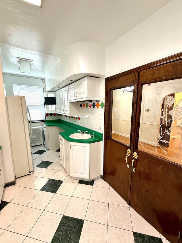 7267 Yellowstone Blvd, Forest Hills, NY 11375 - kitchen featuring freestanding refrigerator, white cabinetry, and light tile patterned floors