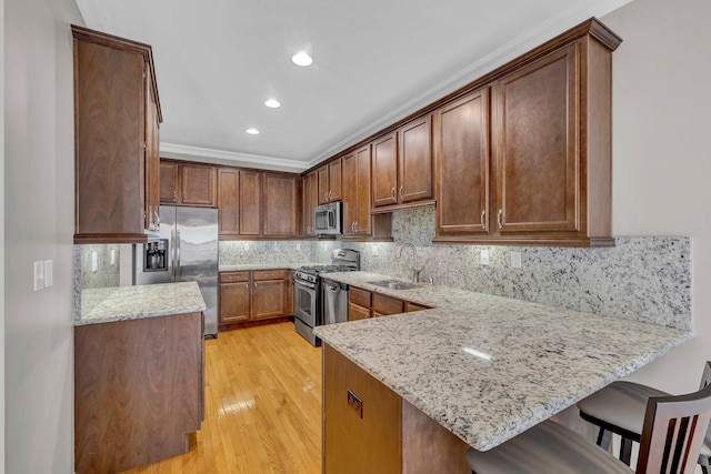 2509 Sylvan Loop, Wappingers Falls, NY 12590 - kitchen with stainless steel appliances, a peninsula, light stone counters, light wood-style floors, and tasteful backsplash