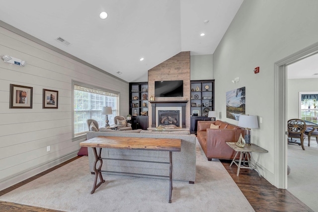 2509 Sylvan Loop, Wappingers Falls, NY 12590 - living area featuring vaulted ceiling, dark wood-type flooring, a large fireplace, recessed lighting, and wooden walls