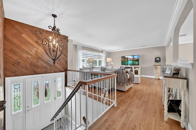 69 Oakland Pl, Nanuet, NY 10954 - corridor with an upstairs landing, a chandelier, crown molding, and light wood-style floors