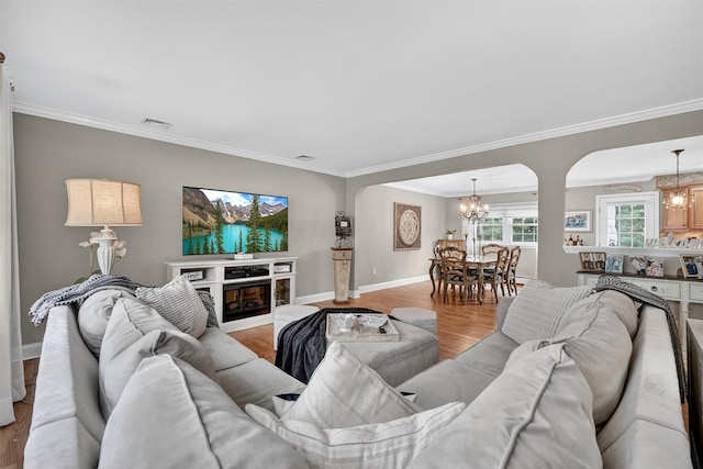 69 Oakland Pl, Nanuet, NY 10954 - living area featuring a chandelier, wood finished floors, ornamental molding, and arched walkways