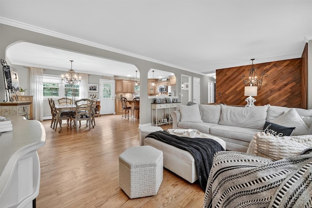 69 Oakland Pl, Nanuet, NY 10954 - living area with a chandelier, ornamental molding, light wood-style flooring, arched walkways, and wood walls