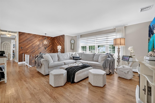 69 Oakland Pl, Nanuet, NY 10954 - living room featuring wood walls, light wood-style flooring, crown molding, and a chandelier