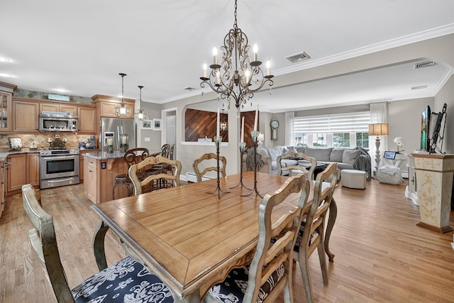 69 Oakland Pl, Nanuet, NY 10954 - dining room with light wood-type flooring, a chandelier, and crown molding