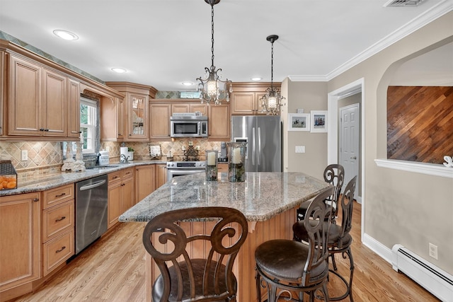 69 Oakland Pl, Nanuet, NY 10954 - kitchen featuring stainless steel appliances, a baseboard heating unit, light wood-type flooring, backsplash, and ornamental molding