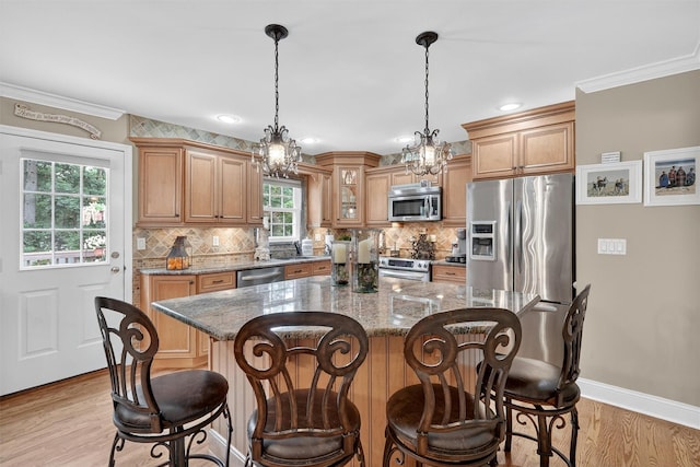 69 Oakland Pl, Nanuet, NY 10954 - kitchen with appliances with stainless steel finishes, light wood finished floors, decorative backsplash, stone counters, and ornamental molding