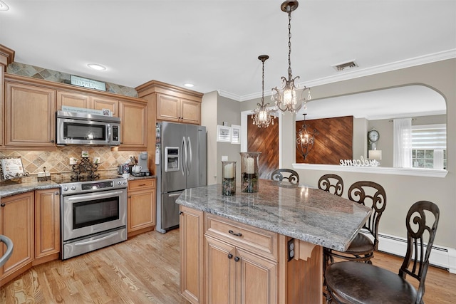 69 Oakland Pl, Nanuet, NY 10954 - kitchen featuring appliances with stainless steel finishes, a breakfast bar area, light wood-style flooring, a center island, and tasteful backsplash