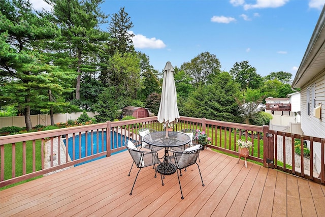 69 Oakland Pl, Nanuet, NY 10954 - wooden terrace with a storage shed, outdoor dining space, a fenced backyard, and view of wooded area