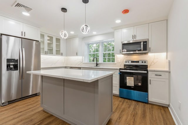 24 Sol Dr, Carmel, NY 10512 - kitchen featuring stainless steel appliances, wood finished floors, white cabinets, decorative backsplash, and recessed lighting