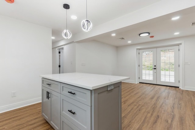 24 Sol Dr, Carmel, NY 10512 - kitchen featuring french doors, light wood-style flooring, gray cabinets, a kitchen island, and hanging light fixtures
