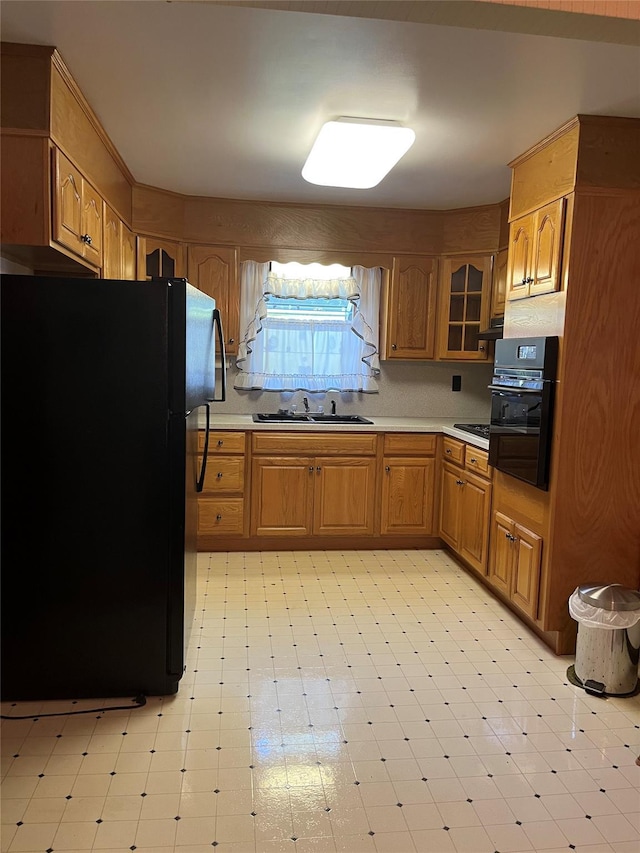 11 Crescent Dr, Cortlandt Manor, NY 10567 - kitchen featuring black appliances, light floors, light countertops, brown cabinetry, and glass insert cabinets