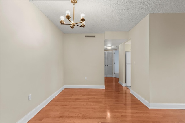 10Stewart Place 3Hw, White Plains, NY 10601 - unfurnished room featuring light wood-style flooring, a chandelier, and a textured ceiling