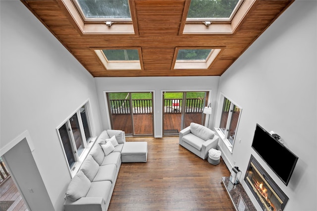 32 Pine Dr, Pound Ridge, NY 10576 - living room with a skylight, wood ceiling, wood finished floors, lofted ceiling, and a glass covered fireplace