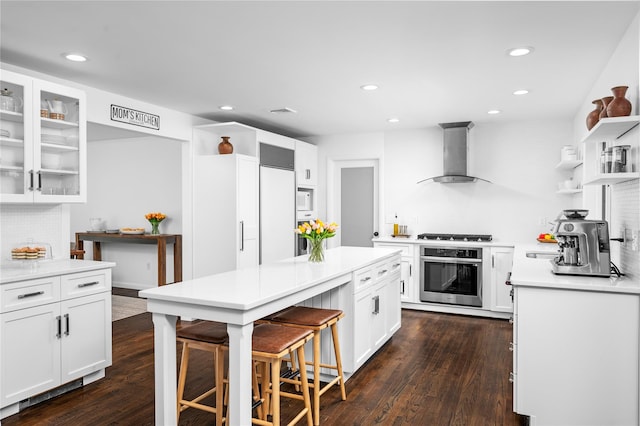 32 Pine Dr, Pound Ridge, NY 10576 - kitchen with oven, wall chimney range hood, open shelves, white cabinets, and a breakfast bar