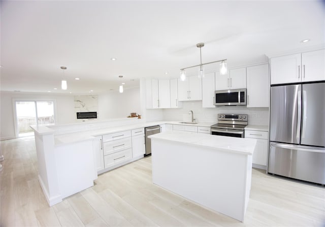 59 Stratford Grn Unit 59, Farmingdale, NY 11735 - kitchen featuring stainless steel appliances, a peninsula, light countertops, backsplash, and white cabinets