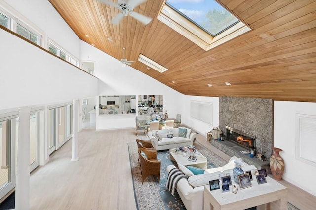 61 Hidden Cove Ct, Southampton, NY 11968 - living room featuring a skylight, wood ceiling, ceiling fan, a stone fireplace, and wood finished floors