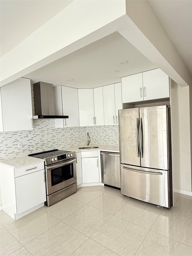 756 40th St Unit 1R, Brooklyn, NY 11232 - kitchen featuring appliances with stainless steel finishes, wall chimney range hood, light countertops, and white cabinetry