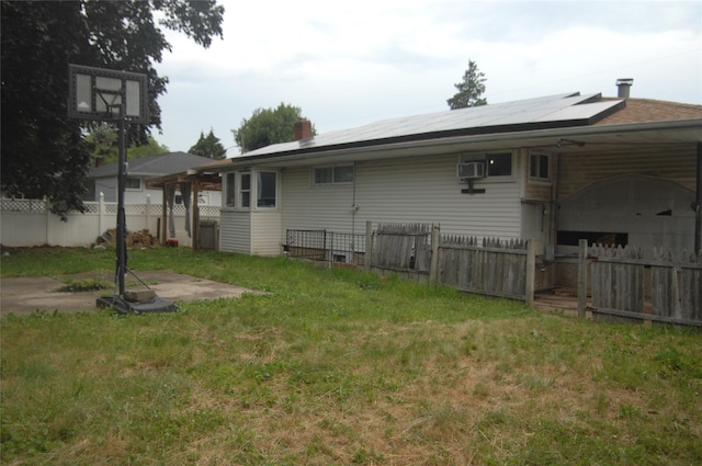 176 Floyd St, Brentwood, NY 11717 - back of house featuring a fenced backyard, solar panels, and a wall mounted AC
