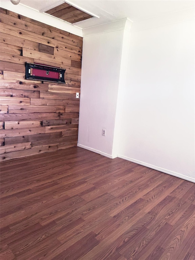 176 Floyd St, Brentwood, NY 11717 - spare room featuring dark wood-style floors, wood walls, and ornamental molding