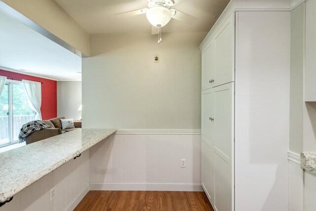 13 Knightsbridge Unit G, Poughkeepsie, NY 12603 - kitchen with wood finished floors, ceiling fan, white cabinetry, light stone countertops, and wainscoting