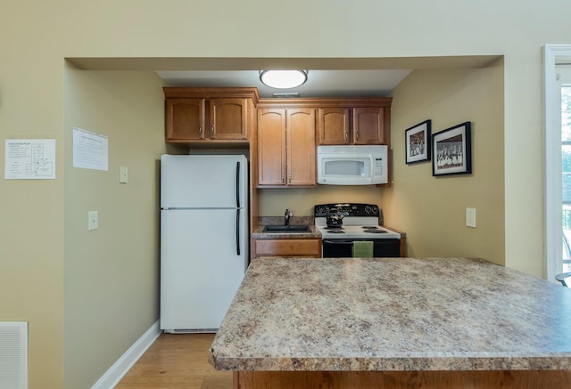 13 Knightsbridge Unit G, Poughkeepsie, NY 12603 - kitchen featuring white appliances, light countertops, light wood finished floors, and brown cabinets